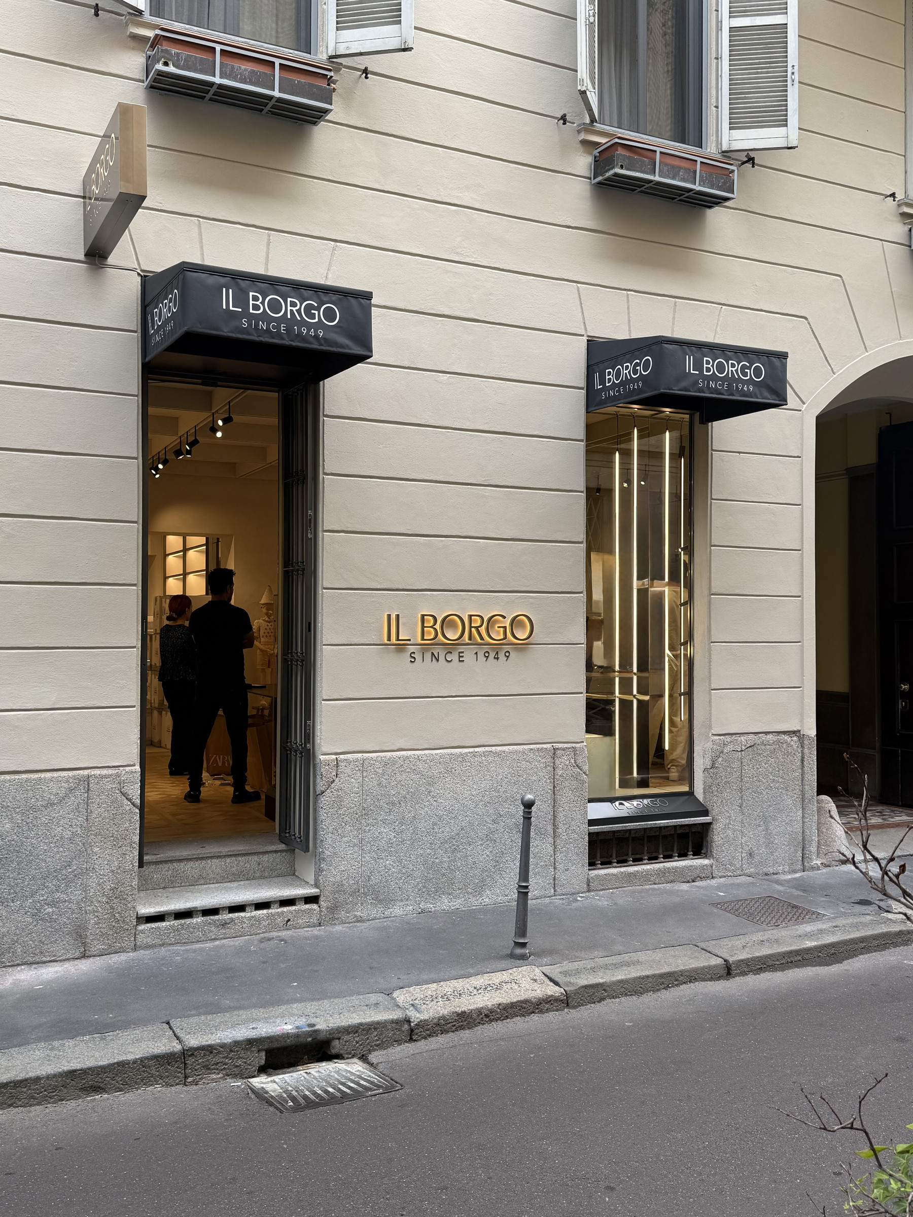 Facciata rifinita della boutique Il Borgo Cashmere in Via Gesù 15, con ingresso, vetrina e insegna illuminata
